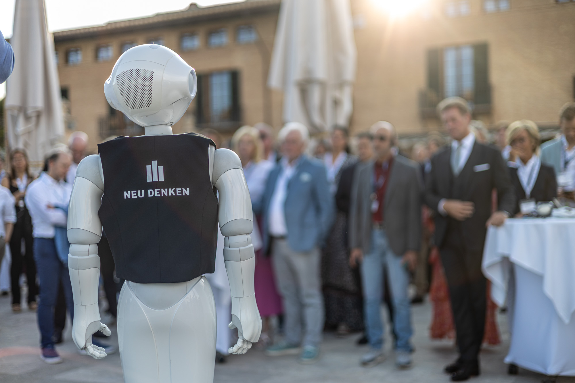 Humanoid robot moving through guests at an outdoor event.