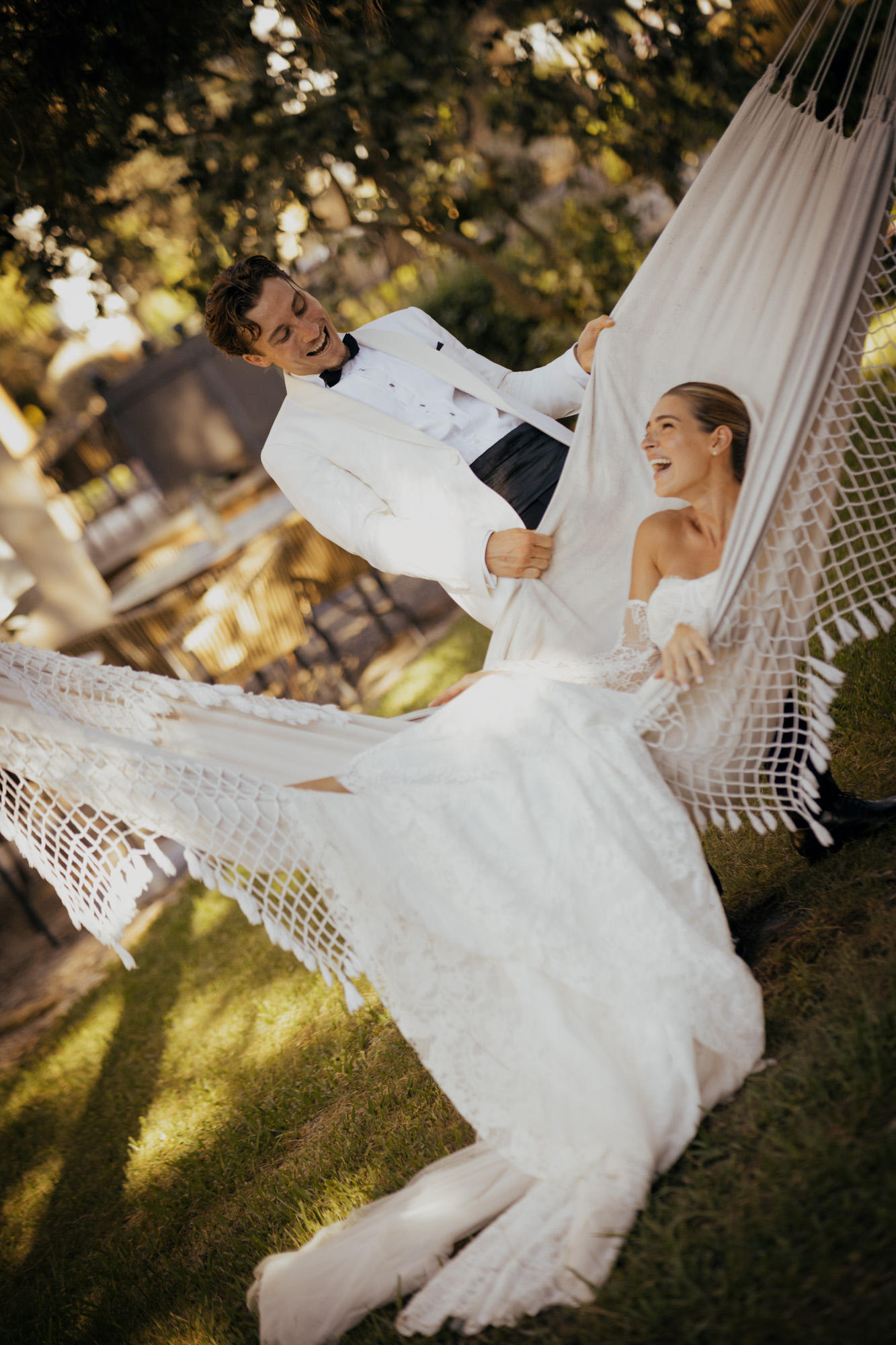 Bride smiling in a hammock during wedding preparations.
