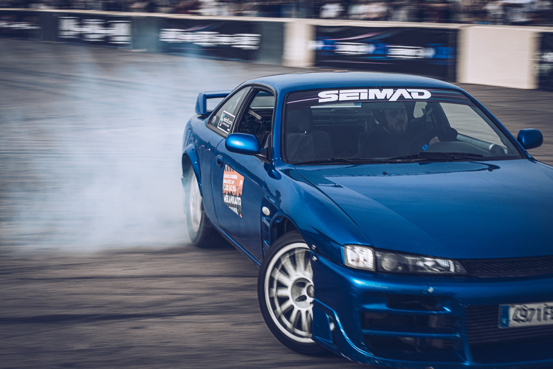 Blue drift car in motion on a race track.