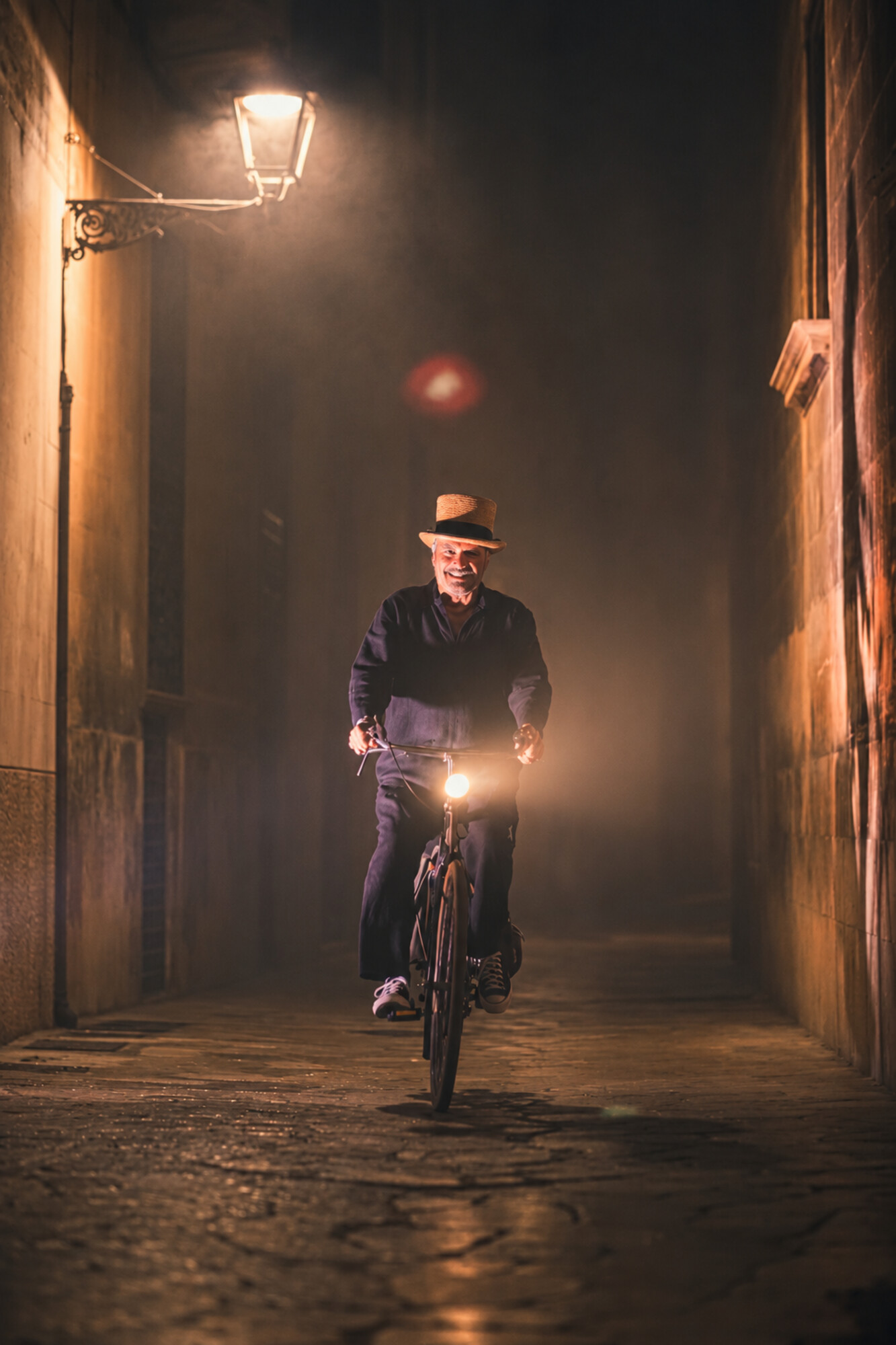 A cyclist riding through a dimly lit alley at night in Mallorca.