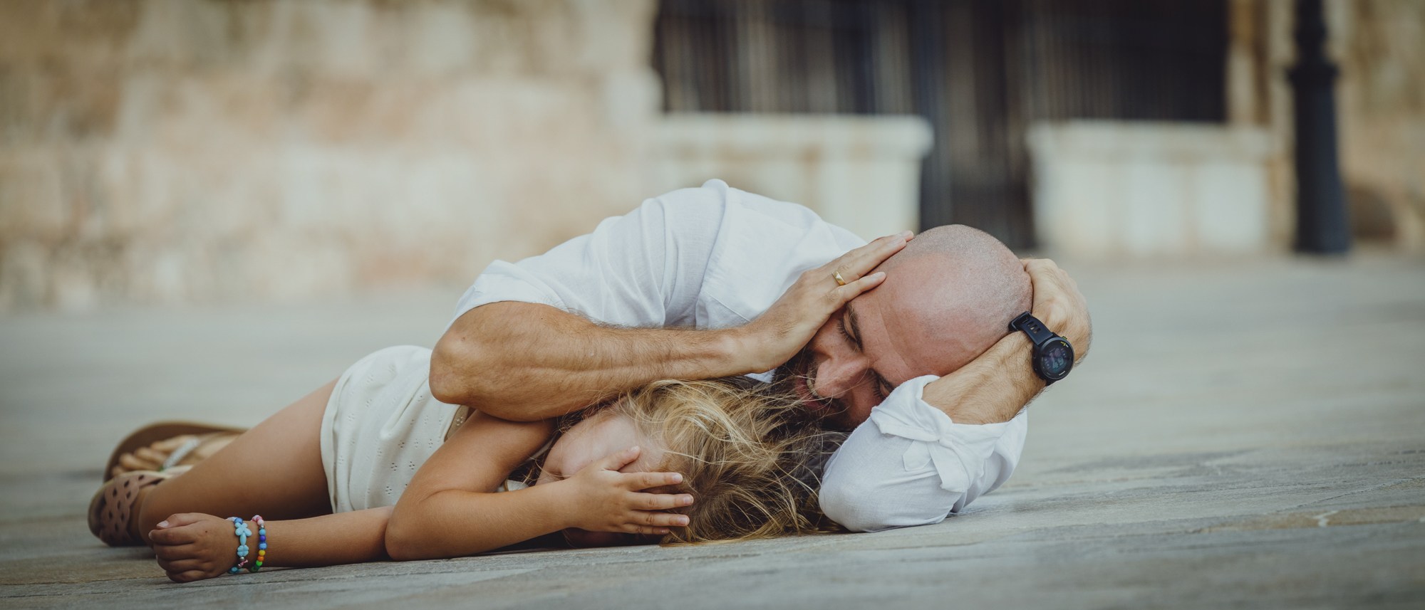 Couple lying together and laughing outdoors.