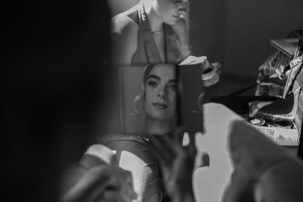 Bride getting ready, seen through a mirror before the wedding.