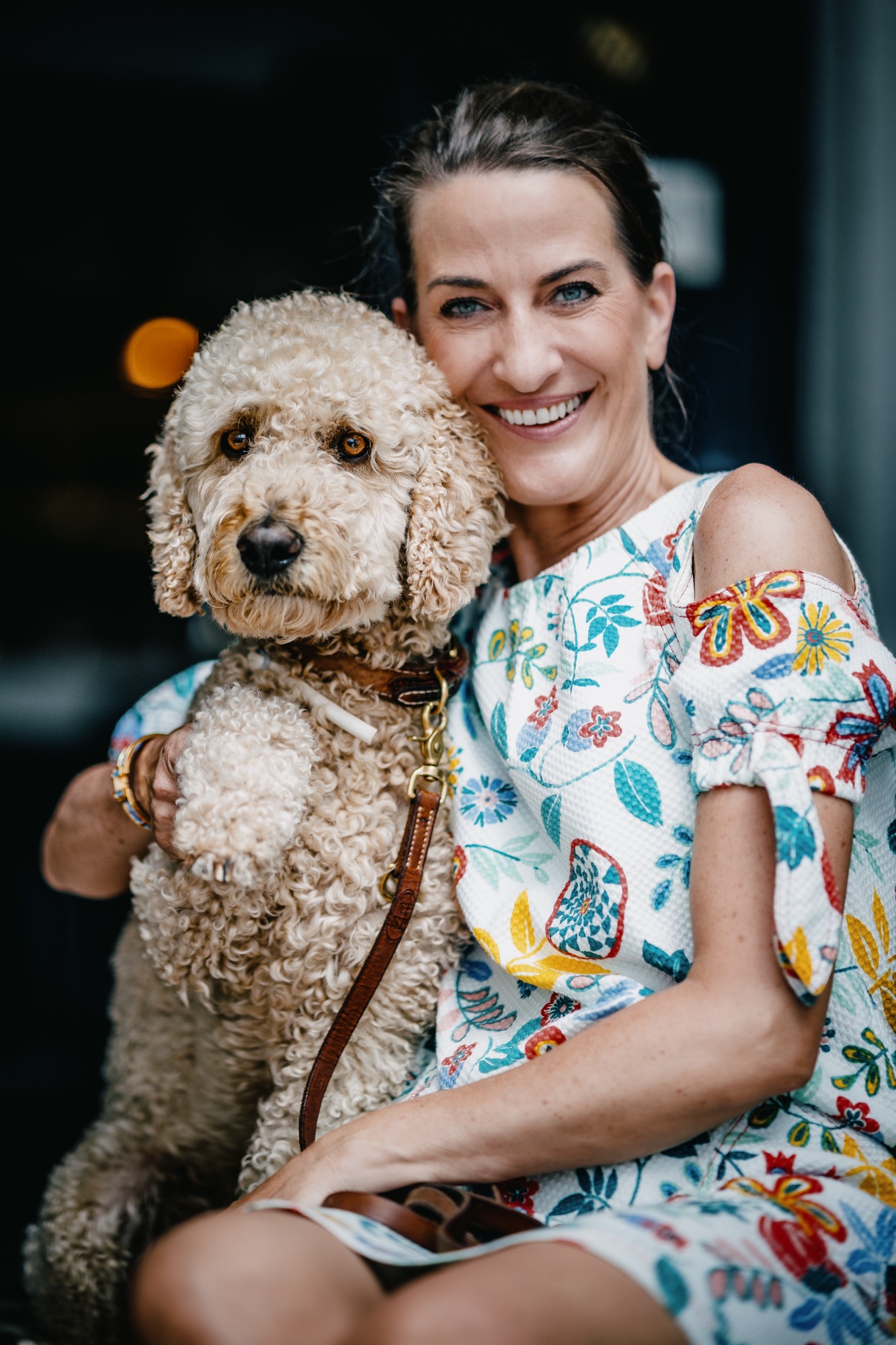 Woman holding a curly-haired dog.