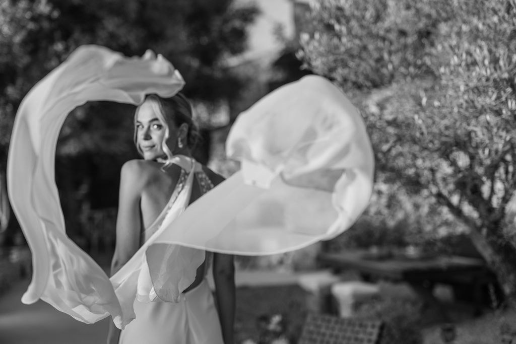 Bride moving through the day as her veil catches the air.